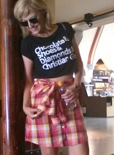 Mulher vestindo uma  blusa cropped e uma camisa amarrada como saia.