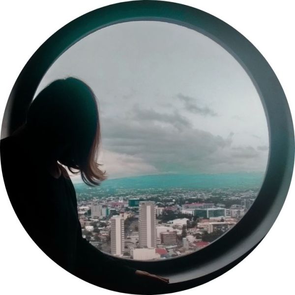 Silhueta de mulher em janela redonda com vista aérea da cidade de San Jose. (capa do post sobre a Costa Rica).